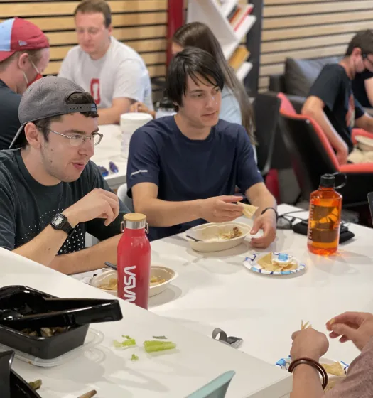 Group of students eating around a table 