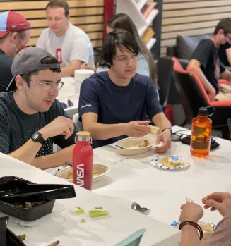 Group of students eating around a table 