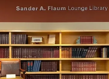 library, wall of books with words above them "sander A Flaum lounge library