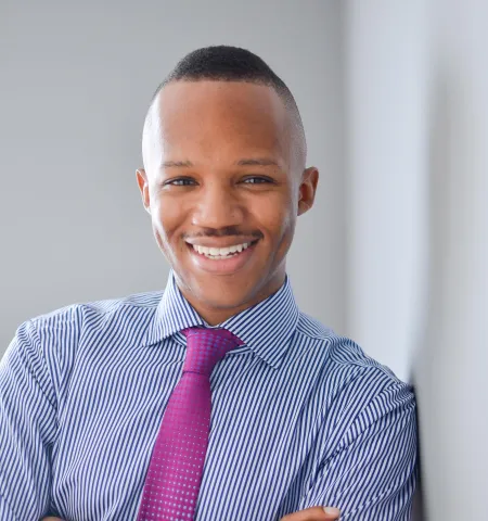 Photo of James Jones in shirt and tie leaning against a wall