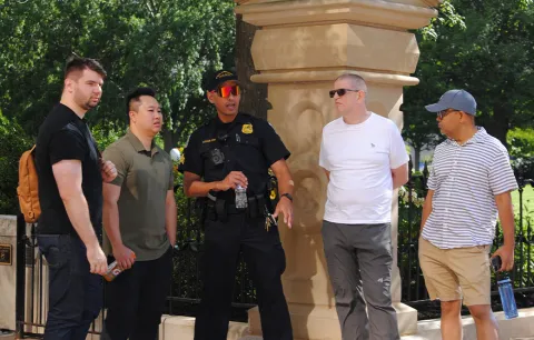 (From left) Police officers from Seattle stand outside in downtown Columbus during this summer’s Pride March and learn about Columbus Dialogue Team actions with explanations from Columbus Police Sgt. Kolin Straub, center and Glenn College Professors Cliff Stott and Russell Hassan.