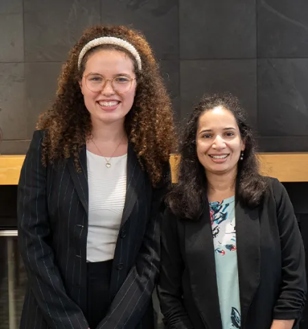 A student intern smiling next to her internship advisor.