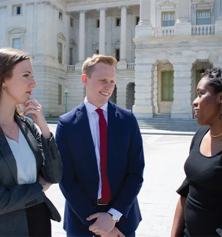 Glenn College 2022 MPA-DC graduates (from left) Haley Foster, Spencer Love, and Irene Lewis engage in a discussion outside the U.S. Capitol Building.