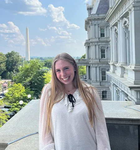 Glenn College student Nina Greenberg stands outside on the vice president’s balcony at the White House, right across from the West Wing, with Washington Monument in the background.
