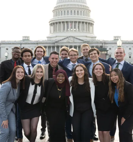 Fifteen Glenn College Washington Academic Internship Program Fellows pose for a photo in front of the Capitol Building in 2023.