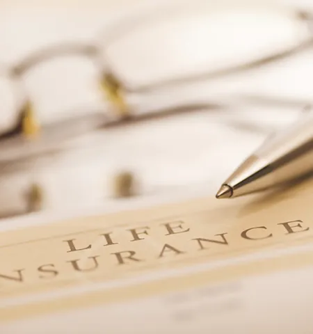 a pen and a pair of glasses sit on a piece of paper titled Life Insurance