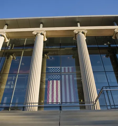 The columns at the front of Page Hall at The Ohio University with an American flag hanging in the window