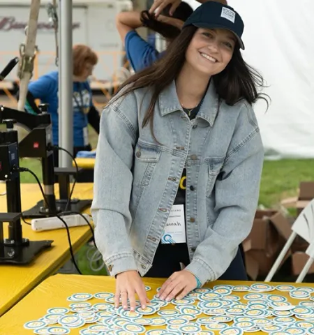 Glenn College graduate and Cleveland Clinic assistant director of development Hannah Zoldesy works in a tent by a table of bike jersey patches at the Bike to Cure patch station for VeloSano, a fundraising movement to beat cancer.
