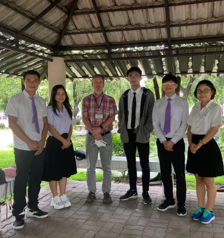 John Glenn College of Public Affairs Professor Josh Hawley, second from left, standing under an outdoor roof with five students at Chiang Mai University 