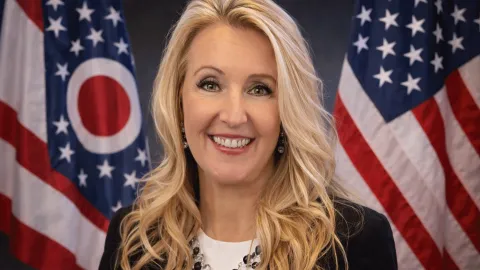 photo of Catherine Farina-Molnar in front of the American and Ohio flag