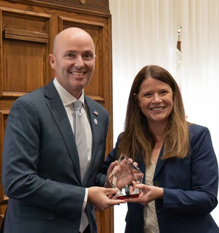 Utah Gov. Spencer Cox, left, and John Glenn College of Public Affairs Acting Dean Stephanie Moulton hold the John Glenn Excellence in Public Service Award.