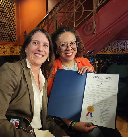 Professor Jill Clark, left, and Yolanda Owens, vice chair of the Columbus and Franklin County Local Food Board, hold the resolution